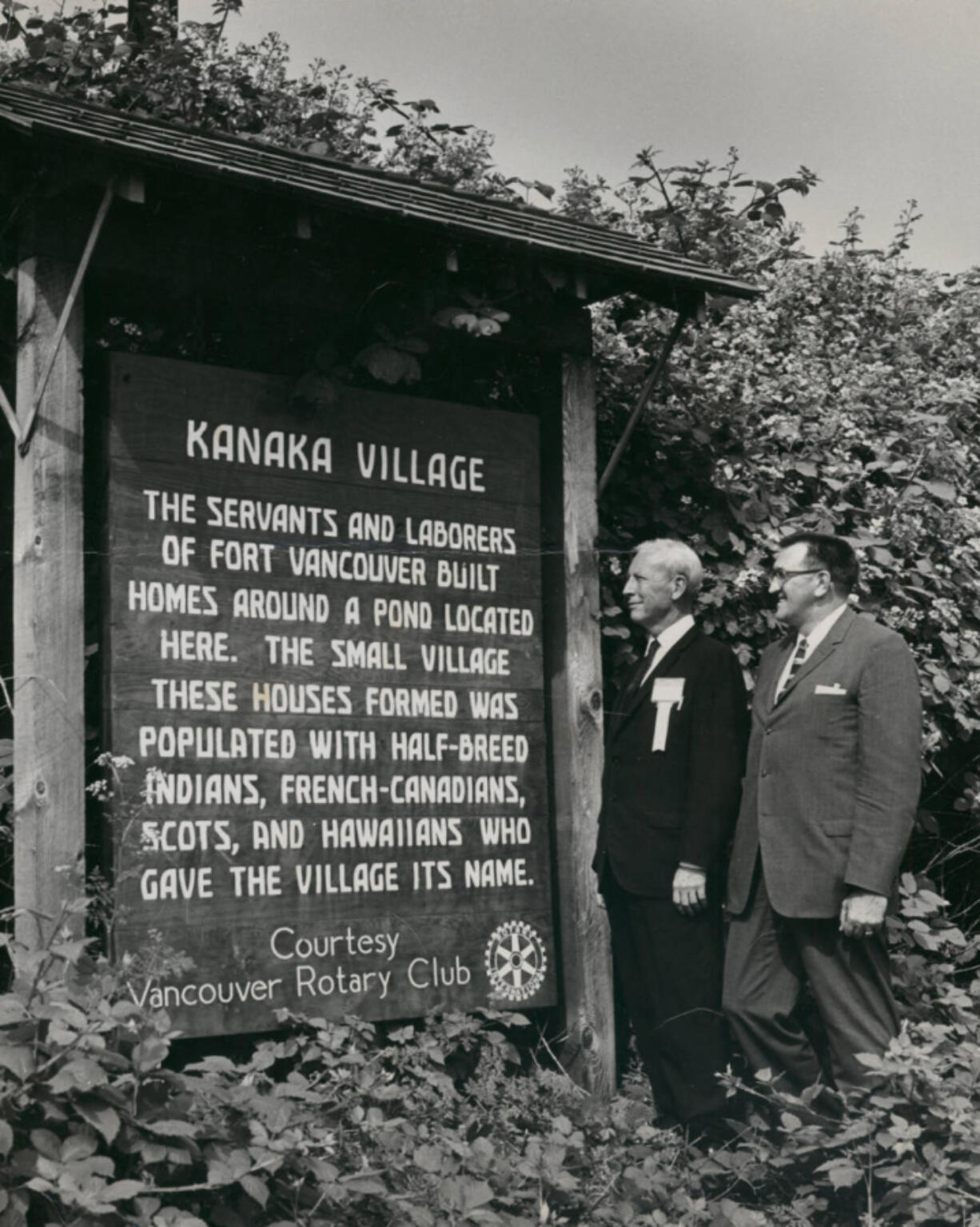 On the right, Kenneth Teter, once a Vancouver city councilman (1956-1963), stands beside an unidentified man examining an unfortunately worded sign (from today's perspective) donated by the Rotary Club describing the Hudson's Bay Company employees' village that once stood outside Fort Vancouver.