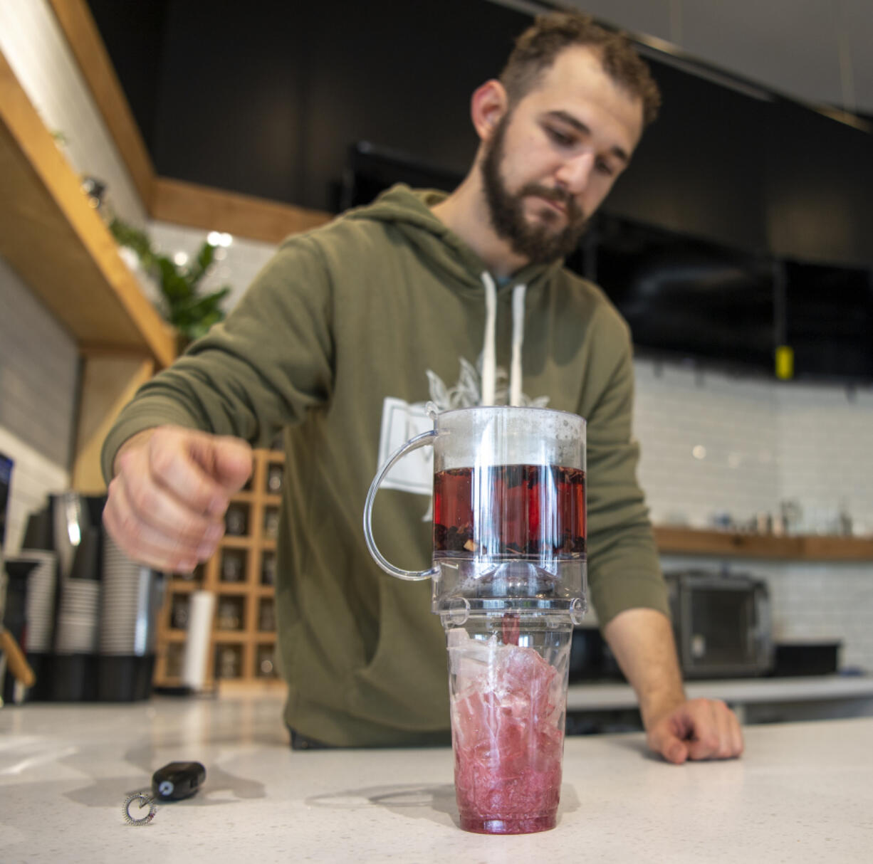 IV Tea Co. owner Michael Hearn III brews a cup of papaya blackberry fruit tea with edible glitter at IV Tea on Broadway in Vancouver.