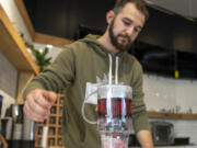 IV Tea Co. owner Michael Hearn III brews a cup of papaya blackberry fruit tea with edible glitter at IV Tea on Broadway in Vancouver.