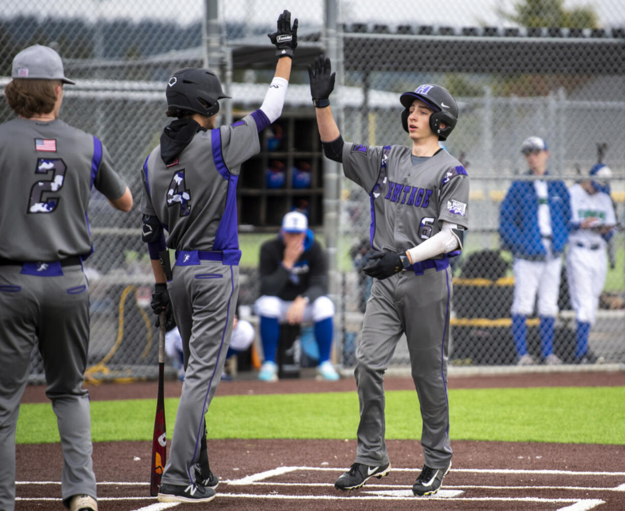 Heritage's Daniel Kehler, right, celebrates with teammates after a solo home run Wednesday, April 27, 2022, during the Timberwolves' 7-1 loss to Mountain View at Union High School.