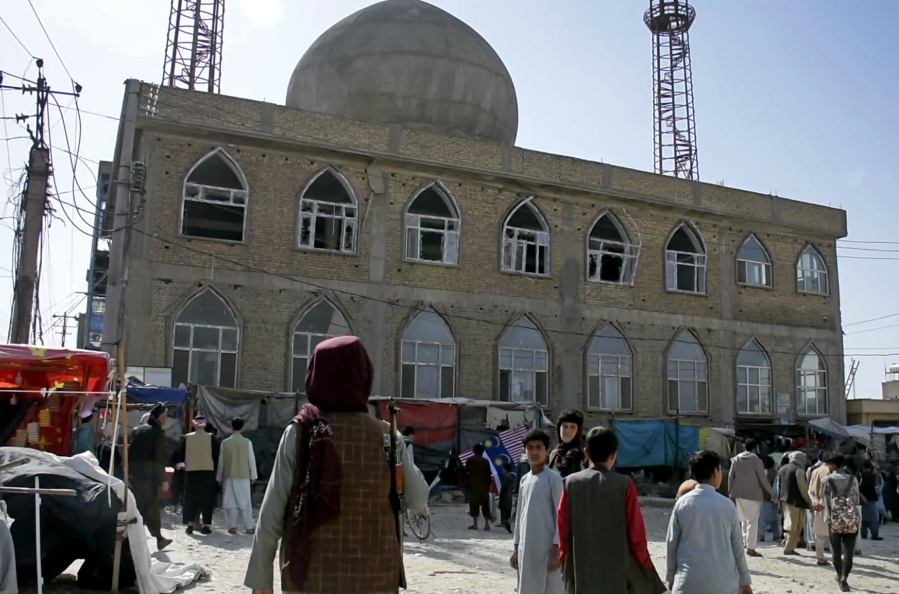 FILE - This frame grab image from video, shows a Taliban fighter standing guard outside the site of a bomb explosion inside a mosque, in Mazar-e-Sharif province, Afghanistan, Thursday, April 21, 2022. A deadly Islamic State affiliate on Friday, April 22, 2022, claimed a series of bombings  a day earlier that targeted Afghanistan's minority Shiite Muslims, while Pakistan issued a warning of IS threats in its eastern Punjab province.