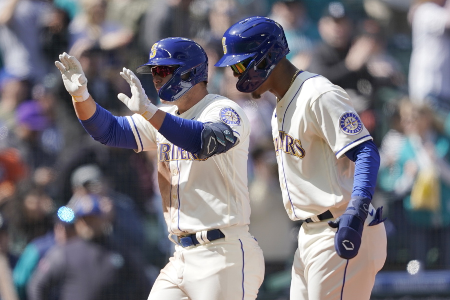 Seattle Mariners' Ty France left, reacts with Julio Rodriguez, right, after France hit a three-run home run to score Rodriguez and Adam Frazier during the fourth inning of a baseball game against the Houston Astros, Sunday, April 17, 2022, in Seattle. (AP Photo/Ted S.