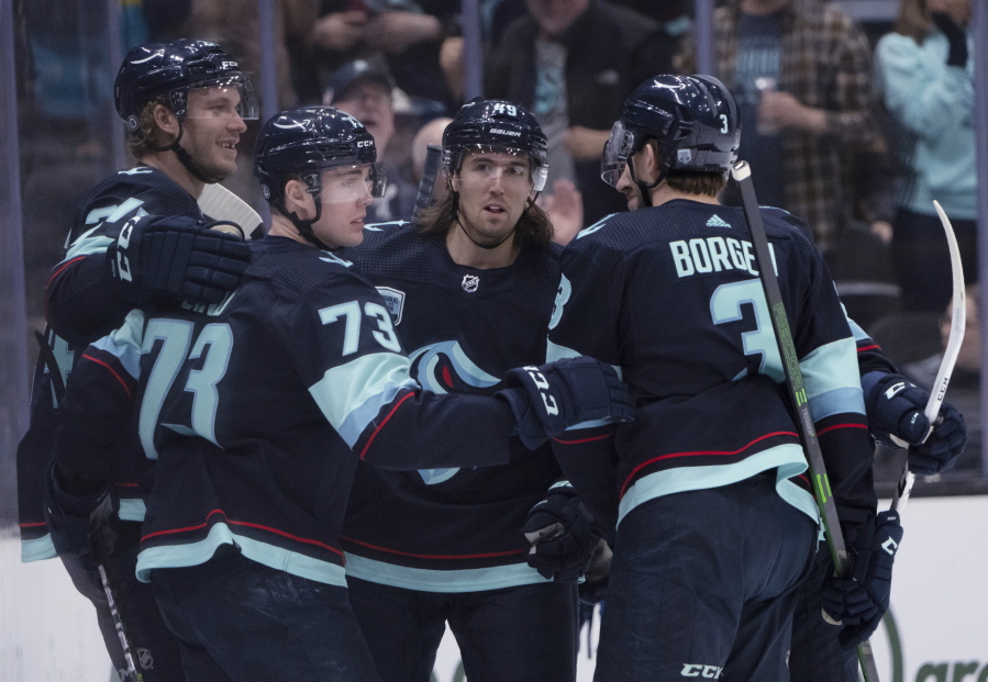 Seattle Kraken defenseman Jamie Oleksiak, forward Kole Lind, forward Victor Rask and defenseman Will Borgen, from left, celebrate a goal during the first period of the team's NHL hockey game against the Colorado Avalanche, Wednesday, April 20, 2022, in Seattle.
