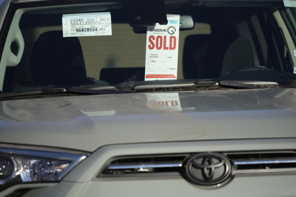 FILE - A sold tag hangs from the inside rear-view mirror of a 2022 4Runner sports-utility vehicle as it sits in an empty storage lot at a Toyota dealership Sunday, Feb. 27, 2022, in Englewood, Colo.