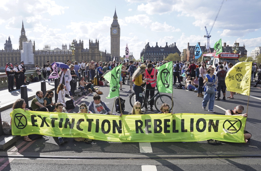 Demonstrators take part in an Extinction Rebellion protest on Westminster Bridge in London, Friday, April 15, 2022. Climate-change protesters have snarled traffic by blocking four London bridges. Cars and red double-decker buses backed up along roads as hundreds of Extinction Rebellion activists occupied London's Waterloo, Blackfriars, Lambeth and Westminster bridges, calling for an end to new fossil fuel investments.