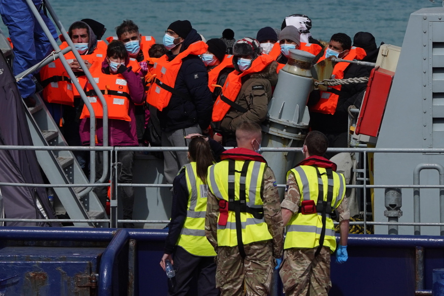 A group of people thought to be migrants are brought in to Dover, Kent, England, by the RNLI, following a small boat incident in the Channel, Thursday April 14, 2022. Britain's Conservative government has struck a deal with Rwanda to send some asylum-seekers thousands of miles away to the East African country. Opposition politicians and refugee groups are condemning the plan as unworkable, inhumane and a waste of public money.