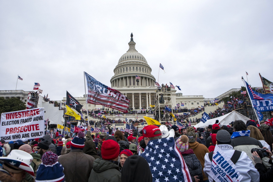 FILE - Rioters loyal to President Donald Trump rally at the U.S. Capitol in Washington on Jan. 6, 2021. A federal judge is set to deliver a verdict in the trial of a New Mexico man who claims a police officer waved him into the U.S. Capitol building after a riot erupted on Jan. 6, 2021. U.S. District Judge Trevor McFadden didn't immediately rule on Wednesday after hearing attorneys' closing arguments in the trial of Matthew Martin. McFadden heard testimony without a jury after Martin's trial started on Tuesday. He is expected to announce a verdict on Wednesday afternoon.