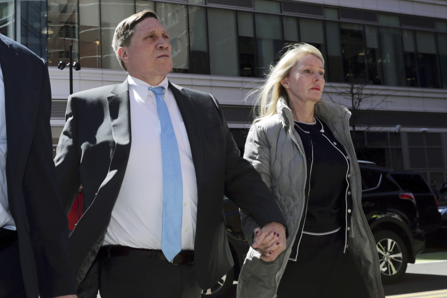 John Wilson, left, arrives at federal court, April 3, 2019, with his wife Leslie to face charges in a nationwide college admissions bribery scandal in Boston. Wilson, a head of a private equity firm and former Staples Inc. executive, was convicted in March 2022 of bribery and fraud charges for trying to pay more than $1.2 million to buy his three children's way into elite universities. Wilson's attorney's appealed the conviction in a filing Monday April 25, 2022, alleging prosecutorial flaws and an unfair trial.