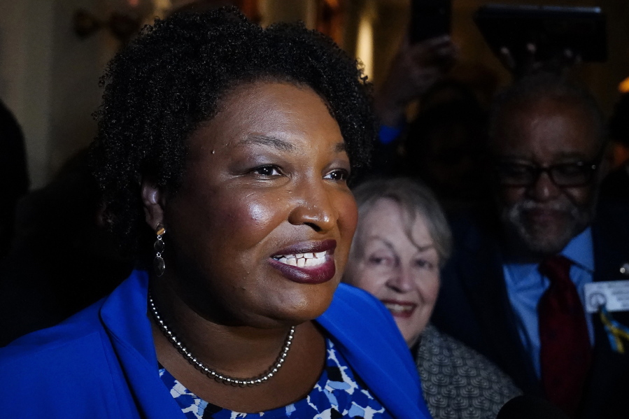 FILE - Georgia gubernatorial Democratic candidate Stacey Abrams talks to the media after qualifying for the 2022 election on Tuesday, March 8, 2022, in Atlanta.  Abrams has become a millionaire. A disclosure filed in March shows the candidate for governor is worth $3.17 million, thanks mostly to book and speaking income. Abrams was worth $109,000 in 2018 when she first ran for governor.