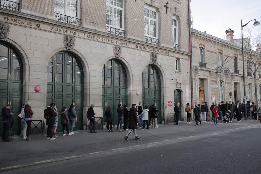 People queue before voting in the first round of the French presidential election in Paris, Sunday, April 10, 2022. The polls opened at 8am in France for the first round of its presidential election where up to 48 million eligible French voters will be choosing between 12 candidates.