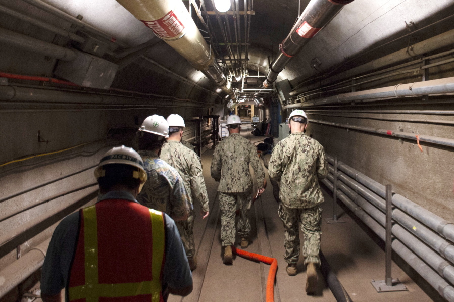 FILE - In this Dec. 23, 2021, photo provided by the U.S. Navy, Rear Adm. John Korka, Commander, Naval Facilities Engineering Systems Command (NAVFAC), and Chief of Civil Engineers, leads Navy and civilian water quality recovery experts through the tunnels of the Red Hill Bulk Fuel Storage Facility, near Pearl Harbor, Hawaii. The U.S. government on Friday, April 22, 2022 dropped its appeals of a Hawaii order requiring it to remove fuel from a massive military fuel storage facility that leaked petroleum into the Navy's water system at Pearl Harbor last year. (Mass Communication Specialist 1st Class Luke McCall/U.S.
