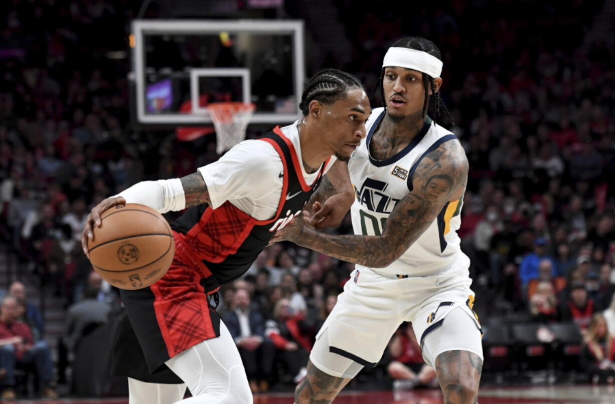 Portland Trail Blazers guard Keon Johnson, left, drives to the basket on Utah Jazz guard Jordan Clarkson, right, during the first half of an NBA basketball game in Portland, Ore., Sunday, April 10, 2022.