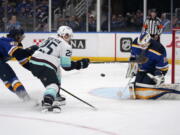 St. Louis Blues goaltender Ville Husso (35) stops a shot by Seattle Kraken's Karson Kuhlman as Blues' Jordan Kyrou, left, defends during the first period of an NHL hockey game Wednesday, April 6, 2022, in St. Louis.