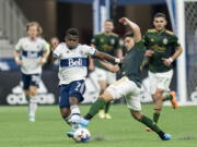 Portland Timbers defender Claudio Bravo (5) tries to breaks up the run of Vancouver Whitecaps forward D?iber Caicedo (7) during the first half of an MLS soccer match Saturday, April 9, 2022, in Vancouver, British Columbia.