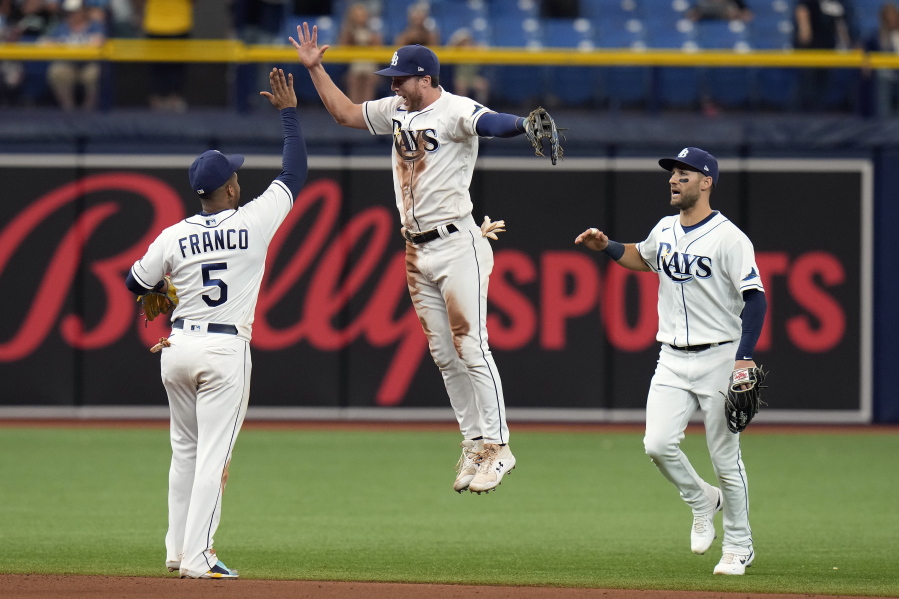 Tampa Bay Rays left fielder Brett Phillips, center, celebrates with shortstop Wander Franco, left, and center fielder Kevin Kiermaier, right, after the team defeated the Seattle Mariners during a baseball game Thursday, April 28, 2022, in St. Petersburg, Fla.