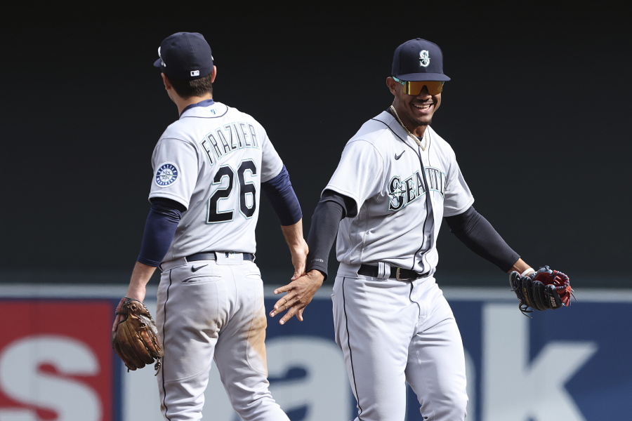 Seattle Mariners second baseman Adam Frazier (26) high fives teammate center fielder Julio Rodriguez in celebration after winning 4-3 against the Minnesota Twins after a baseball game Saturday, April 9, 2022, in Minneapolis.