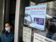 Signs indicating that protective face masks must be worn in classrooms are displayed outside lecture halls at Columbia University, Thursday, April 21, 2022, in the Manhattan borough of New York.