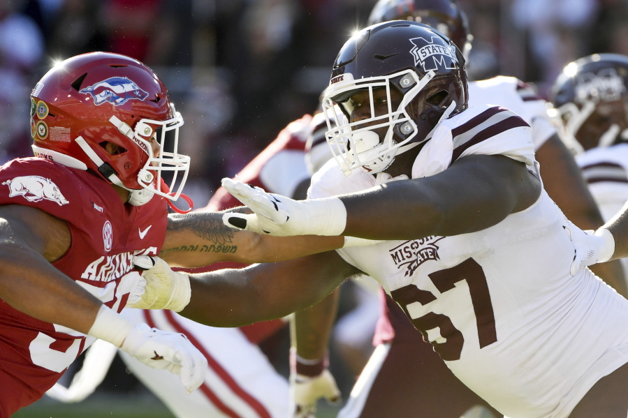 FILE - Mississippi State offensive lineman Charles Cross (67) blocks against Arkansas during an NCAA college football game Nov. 6, 2021, in Fayetteville, Ark. Cross was selected by the Seattle Seahawks during the first round of the NFL draft Thursday, April 28.