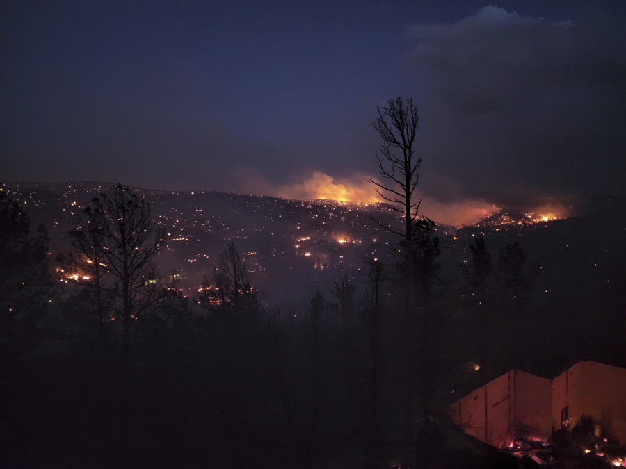 Fire burns along a hillside in the Village of Ruidoso, N.M., on Wednesday, April 13, 2022. Officials say a wildfire has burned about 150 structures, including homes, in the New Mexico town of Ruidoso.