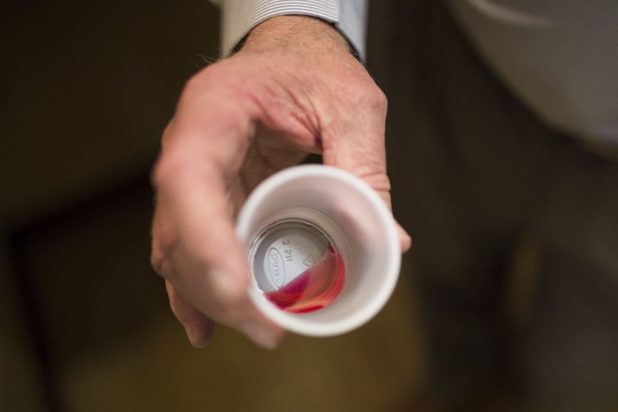 FILE - Paul "Rip" Connell, CEO of Private Clinic North, a methadone clinic, shows a 35 mg liquid dose of methadone at the clinic in Rossville, Ga., on March 7, 2017. A deepening opioid epidemic is prompting the U.S. Department of Justice to warn about discrimination against those who are taking medication to wean themselves off their addiction. In guidelines published Tuesday, April 5, 2022, the DOJ said employers, health care providers, jails and others cannot discriminate against people because they are taking prescribed drugs to treat opioid use disorder. (AP Photo/Kevin D.