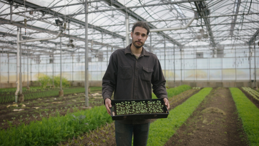 In this photo provided by the Rockefeller Foundation, Jason Grauer, the Seed and Crop Director at Stone Barns, poses for a photo at Stone Barns's greenhouse on April 7, 2021, in Tarrytown, N.Y.  Rockefeller grantee Stone Barns Center for Food and Agriculture is working on innovative, community-based ways to increase access to food and use sustainable environmental practices.