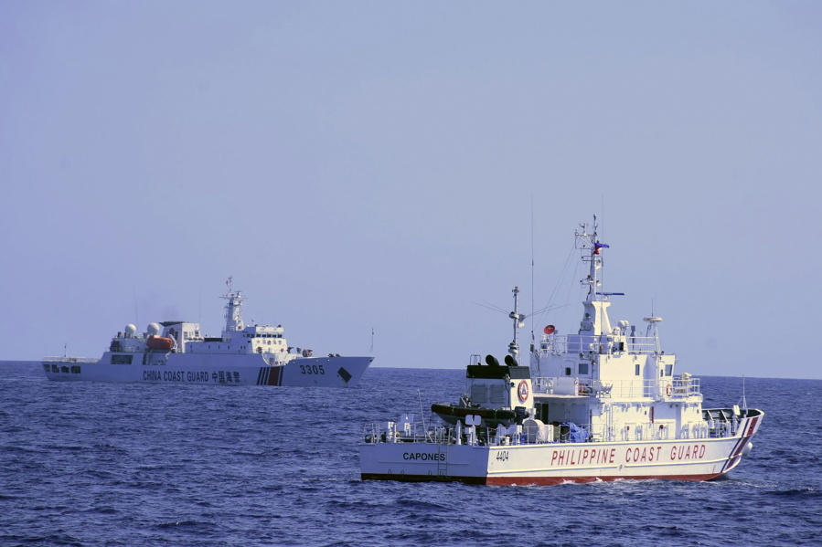 In this photo provided by the Philippine Coast Guard, a Chinese Coast Guard ship sails near a Philippine Coast Guard vessel during its patrol at Bajo de Masinloc, 124 nautical miles west of Zambales province, northwestern Philippines on March 2, 2022. A Chinese coast guard ship last month maneuvered for days near a research vessel deployed by Philippine and Taiwanese scientists to undertake a crucial survey of undersea fault lines west of the northern Philippines, sparking concerns among the scientists on board, officials said Thursday, April 7, 2022.