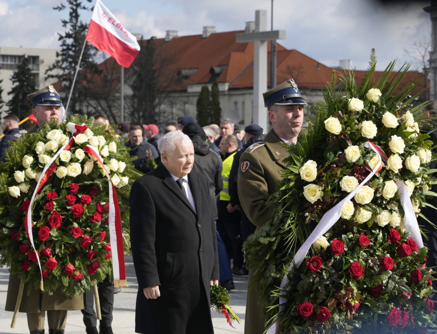 Poland's deputy prime minister and key politician, Jaros?aw Kaczynski,center, pays respect to his twin, the late President Lech Kaczynski, on the 12th anniversary of a plane crash in Russia that killed the president and 95 other prominent Poles, at the monument to the victims in Warsaw, Poland, on Sunday, April 10, 2022. At a time of Russia's war on Ukraine, Poland's government has revived its controversial allegations that the crash was the Kremlin's assassination plan.