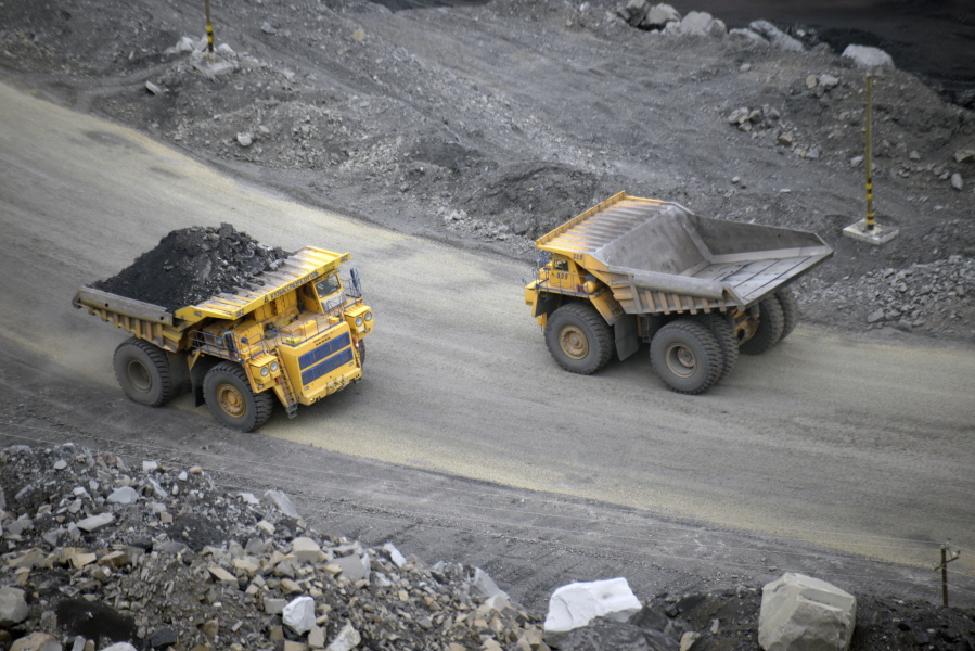 FILE - A loaded dump truck passes an empty truck as it carries away coal at the Kedrovsky open-pit coal mine in Kemerovo, Russia, Tuesday, June 16, 2015. Poland's government has decided to block imports of coal from Russia. The move is an element in a larger strategy to reduce energy dependence on Russia which gained new urgency after the invasion of Ukraine. The government of Prime Minister Mateusz Morawiecki agreed to impose financial penalties on the private entities importing Russian coal into Poland, with Polish customs officials tasked with carrying out checks. (AP Photo/Phelan M.