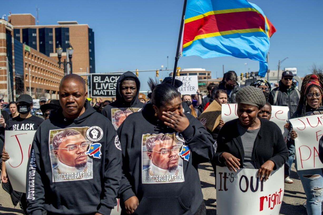 Peter and Dorcas Lyoya, parents of Patrick Lyoya, march with their family and supporters wearing all black on Thursday, April 21, 2022 for a rally at the Capitol in Lansing, Mich. to demand justice in the police shooting that took the life of Patrick Lyoya, a Congolese immigrant.
