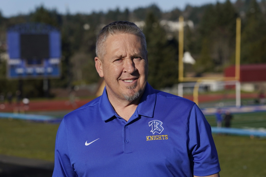 Joe Kennedy, a former assistant football coach at Bremerton High School in Bremerton, Wash., poses for a photo March 9, 2022, at the school's football field. After losing his coaching job for refusing to stop kneeling in prayer with players and spectators on the field immediately after football games, Kennedy will take his arguments before the U.S. Supreme Court on Monday, April 25, 2022, saying the Bremerton School District violated his First Amendment rights by refusing to let him continue praying at midfield after games. (AP Photo/Ted S.