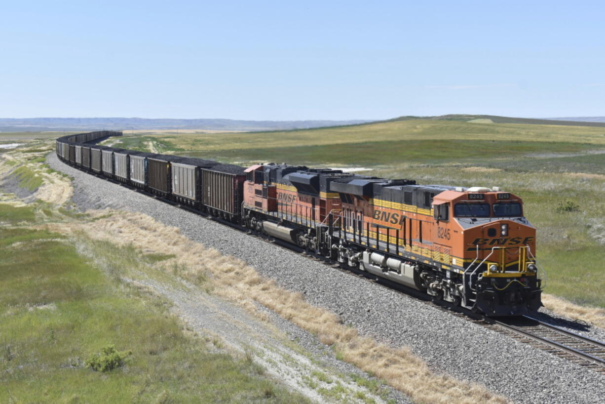 FILE - A BNSF railroad train hauling carloads of coal from the Powder River Basin of Montana and Wyoming is seen east of Hardin, Mont., on July 15, 2020. The major freight railroads are hiring aggressively and asking customers to cut the number of carloads they are shipping to reduce congestion along the rail network in response to concerns from agricultural and ethanol groups that prompted regulators to schedule a hearing on the problems.