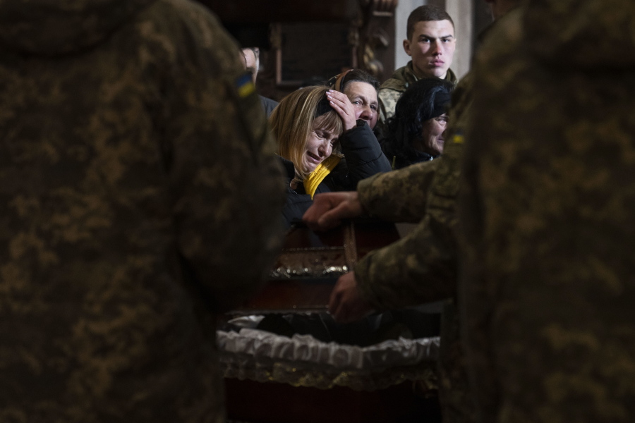 The wife of 44-year-old soldier Tereshko Volodymyr, centre, reacts, during his funeral ceremony, after he killed in action, at the Holy Apostles Peter and Paul Church, in Lviv, western Ukraine, Monday, April 4, 2022.