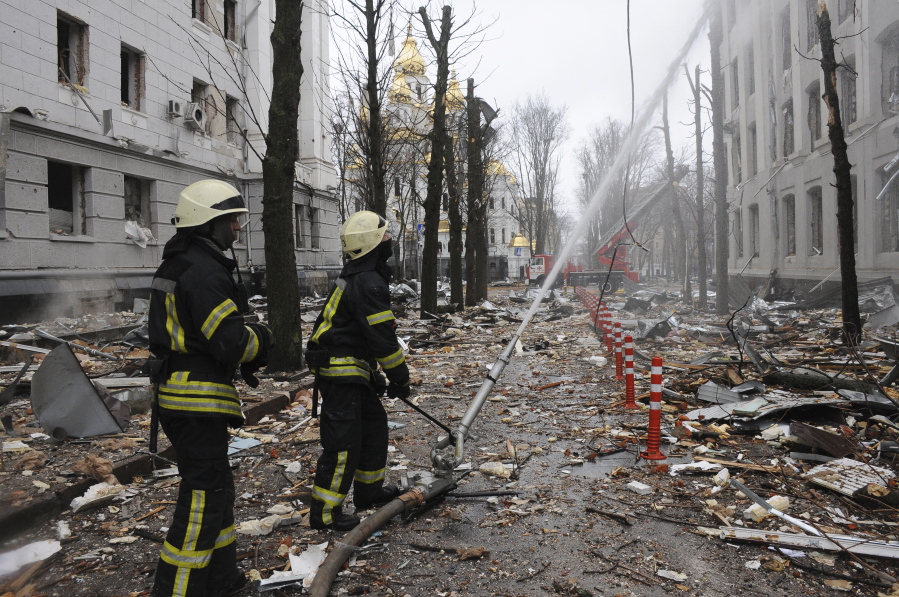 FILE - Firefighters extinguish a building of Ukrainian Security Service (SBU) after a rocket attack in Kharkiv, Ukraine's second-largest city, Ukraine, March 2, 2022.  President Joe Biden has called Russia's war on Ukraine a genocide and accused Vladimir Putin of committing war crimes. But his administration has for weeks grappled with how much intelligence it's willing to give Ukrainian forces trying to stop Putin.