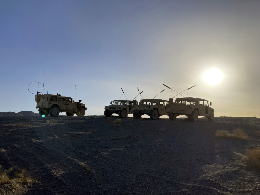 Army vehicles on the ridge, as soldiers from the 2nd Brigade, 1st Cavalry Division, prepare to attack the enemy in the town nearby, during an early morning training exercise at the National Training Center at Fort Irwin, Calif., April 12, 2022. (AP Photo/Lolita C.