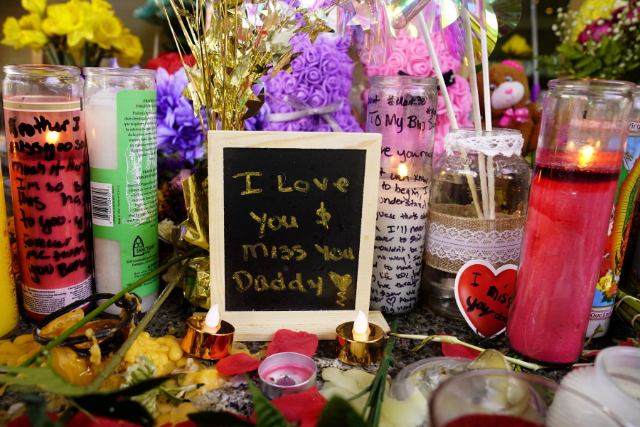 A message left for one of the victims of a recent mass shooting sits among flowers and candles at a memorial in Sacramento, Calif., Saturday, April 9, 2022. The April 3 shooting, which left six dead and 12 wounded, occurred near the state Capitol, an area that in recent years has been rattled by rising crime, protests and the economic drubbing of the pandemic.
