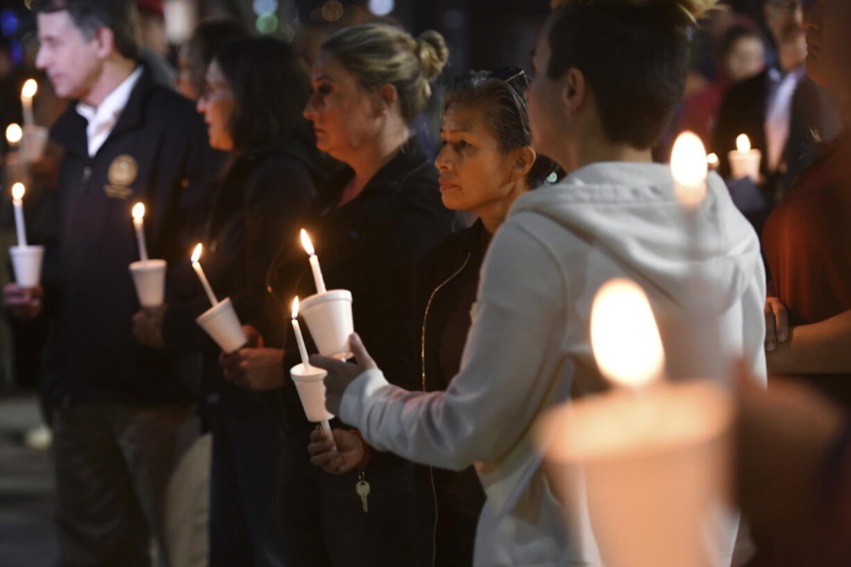 People attend a candlelight vigil for victims of a fatal shooting held at Ali Youssefi Square in Sacramento, Calif., late Monday, April 4, 2022. Multiple people were killed and injured after the shooting that occurred early Sunday.