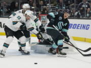 San Jose Sharks goaltender Kaapo Kahkonen, rear, watches as Seattle Kraken center Yanni Gourde, right, vie for the puck with San Jose Sharks left wing Matt Nieto (83) during the second period of an NHL hockey game Friday, April 29, 2022, in Seattle. (AP Photo/Ted S. Warren) (Ted S.