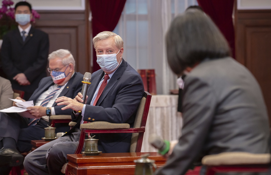 In this photo released by the Taiwan Presidential Office, Sen. Lindsey Graham, R-S.C., left, speaks as Taiwan's President Tsai Ing-wen, right, listens during a meeting at the Presidential Office in Taipei, Taiwan, Friday, April 15, 2022. U.S. lawmakers visiting Taiwan have made a pointed and public declaration of their support for the self-governing island democracy while also issuing a warning to China.