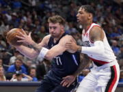 Dallas Mavericks guard Luka Doncic (77) drives to the basket against Portland Trail Blazers forward Didi Louzada during the first half of an NBA basketball game Friday, April 8, 2022, in Dallas.