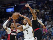 New Orleans Pelicans guard CJ McCollum (3) goes to the basket between Portland Trail Blazers guard Keon Johnson (6) and forward Greg Brown III in the second half of an NBA basketball game in New Orleans, Thursday, April 7, 2022.