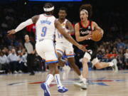 Portland Trail Blazers guard CJ Elleby (16) drives the ball against Trail Blazers guard Zavier Simpson (9) and forward Jaylen Hoard (14) during the first half of an NBA basketball game Tuesday, April 5, 2022, in Oklahoma City.