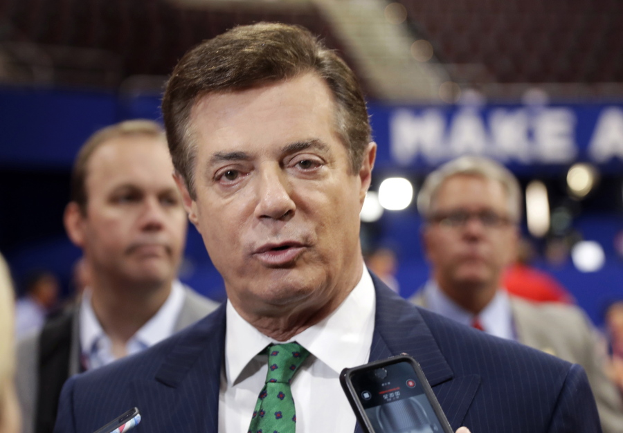 FILE - In this July 17, 2016 file photo, then-Donald Trump campaign chairman Paul Manafort talks to reporters on the floor of the Republican National Convention, in Cleveland. The Justice Department filed a lawsuit Thursday, April 28, 2022 against Donald Trump's former campaign chairman Paul Manafort -- who was convicted in special counsel Robert Mueller's Russia investigation and later pardoned -- seeking to recover nearly $3 million from undeclared foreign bank accounts.