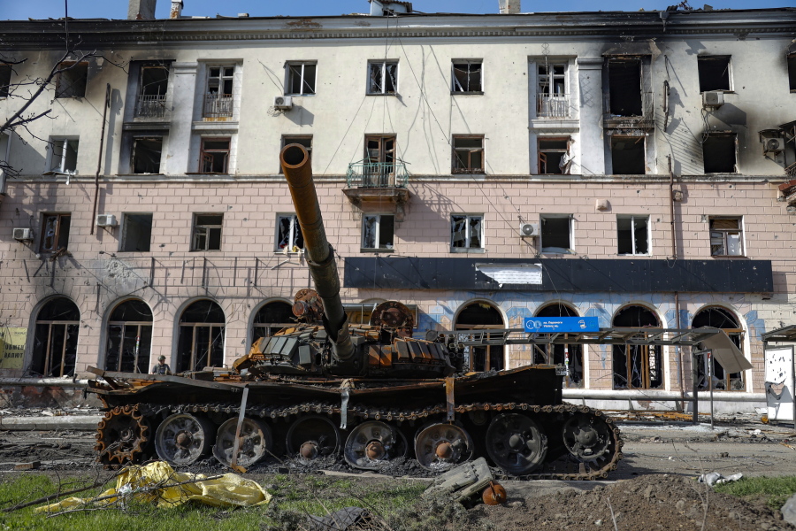 A destroyed tank and a damaged apartment building from heavy fighting are seen in an area controlled by Russian-backed separatist forces in Mariupol, Ukraine, Tuesday, April 26, 2022.