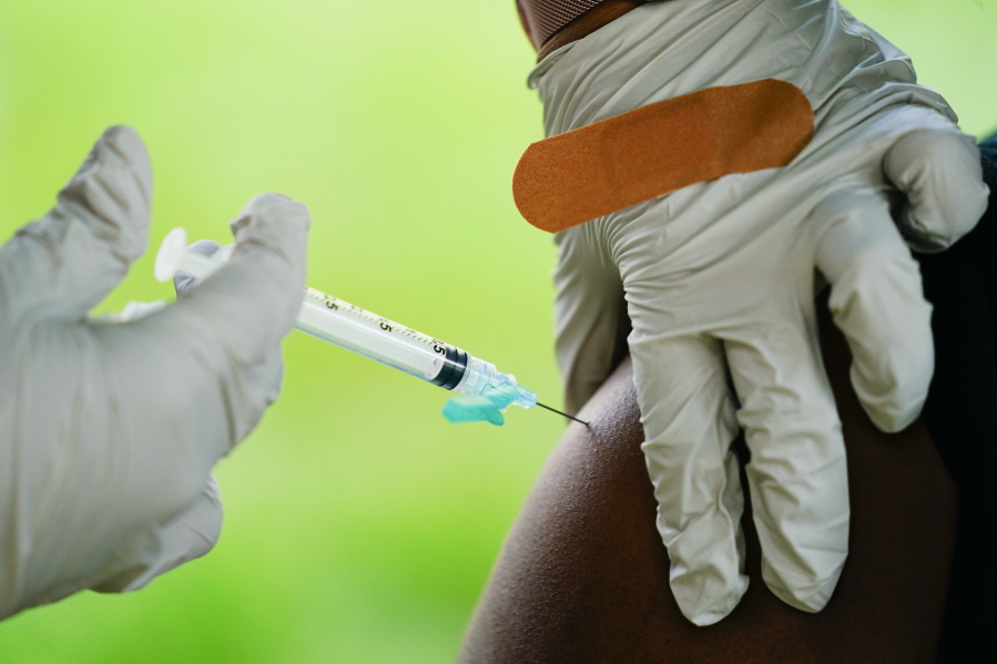 FILE - A health worker administers a dose of COVID-19 vaccine during a vaccination clinic in Reading, Pa. COVID-19 vaccinations are at a critical juncture as companies test whether new approaches like combination shots or nasal drops can keep up with a mutating coronavirus -- even though it's not clear if any change is needed.