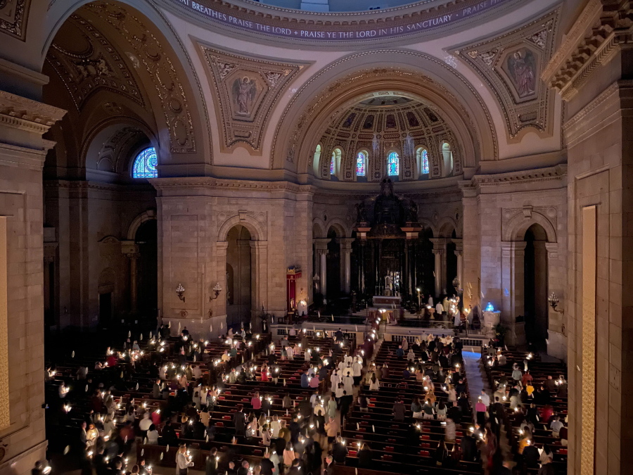Hundreds of people light candles at the beginning of the Easter Vigil Mass at the Cathedral of St. Paul in St. Paul, Minn., on Saturday, April 16, 2022. For many U.S. Christians, this weekend marks the first time since 2019 that they will gather in person on Easter Sunday, a welcome chance to celebrate one of the year's holiest days side by side with fellow congregants.