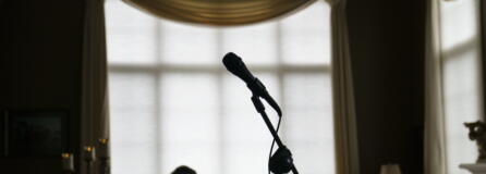 A microphone stands as David Lawyer plays the piano in his living room where his father, Neil Lawyer, would have sung along time to time in Bellevue, Wash., Sunday, March 20, 2022. The elder Lawyer died at age 84 on March 8, 2020, among the first residents of a Seattle area nursing home who succumbed to COVID-19 during the outbreak. At weddings, he joined his sons, grandson and nephew to serenade brides and grooms in a makeshift ensemble dubbed the Moose-Tones. Last October, when one of his granddaughters married, it marked the first family affair without Lawyer there to hold court. The Moose-Tones went on without him. "He would have just been beaming because, you know, it was the most important thing in the world to him late in life, to get together with family," David Lawyer says.