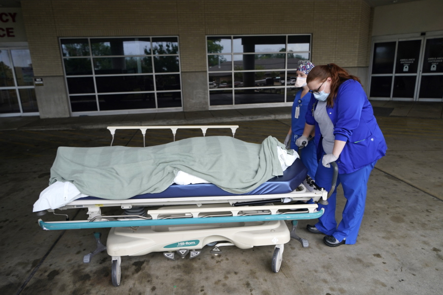 FILE - Medical staff prepare to move the body of a deceased COVID-19 patient to a funeral home van at the Willis-Knighton Medical Center in Shreveport, La., Wednesday, Aug. 18, 2021. Data released by the Centers for Disease Control and Prevention in April 2022 confirms that 2021 was the deadliest year in U.S. history.