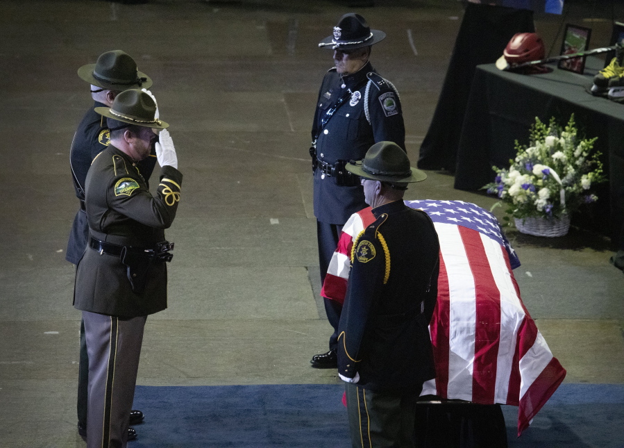 Law enforcement officers salute the casket of Everett police Officer Dan Rocha at a memorial service April 4 at Angel of the Winds Arena in downtown Everett. Rocha was fatally shot while confronting a suspect in a parking lot in late March.