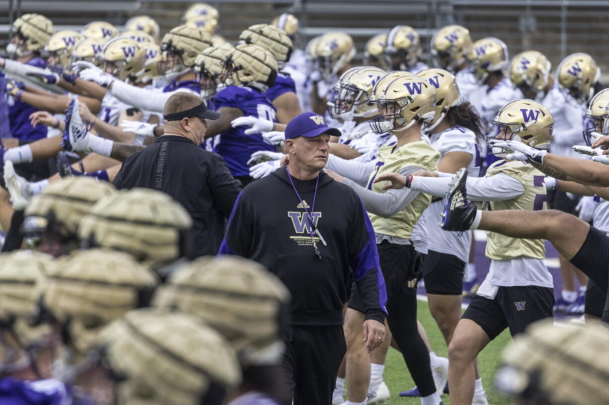 University of Washington coach Kalen Deboer walks among players and staff as they perform early morning warmups during NCAA football practice, Wednesday, March 30, 2022.