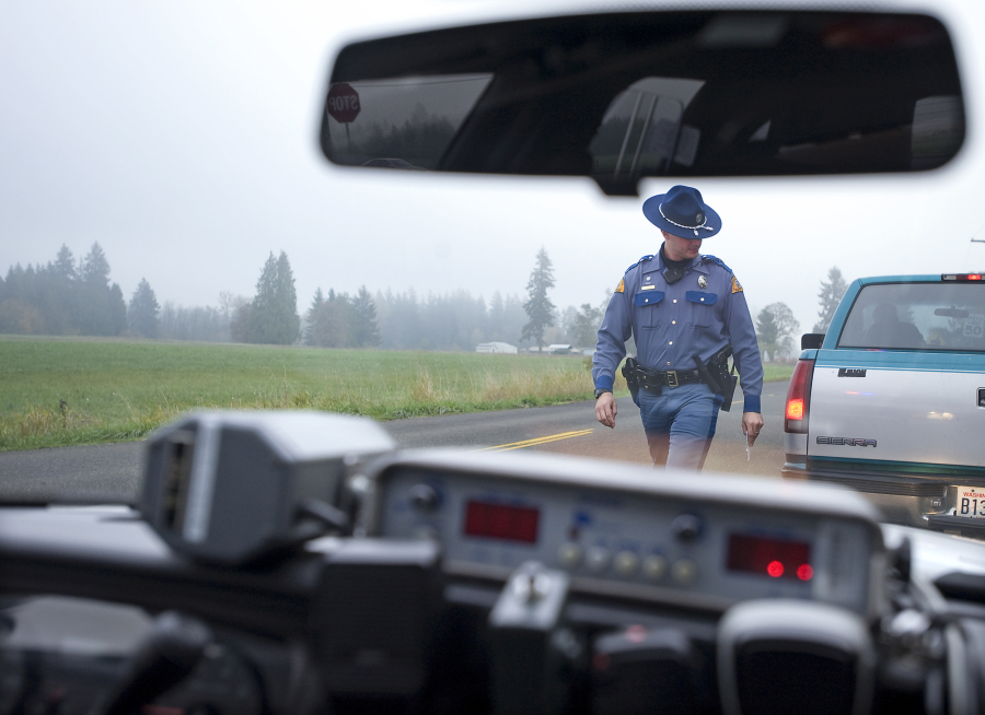 A Washington State Patrol trooper walks back to his cruiser after citing a driver for speeding in east Vancouver in 2010. WSP says drivers are increasingly refusing to stop for troopers - and other law enforcement agencies also say this is becoming a common occurrence.